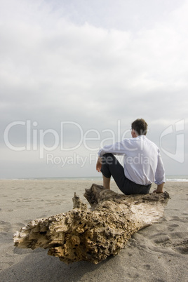 Geschäftsmann sitzt am Strand
