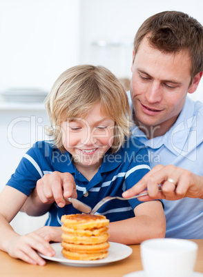 Attentive father and his son eating waffles