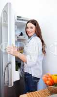 Smiling woman looking for something in the fridge