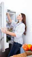 Young woman looking for something in the fridge