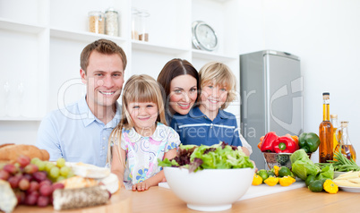 Smiling parents and their children preparing dinner together