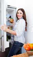 Positive woman taking something of the fridge