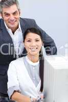 Smiling businesswoman and her manager working at a computer