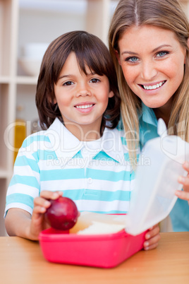 Cheerful little boy and his mother preparing his snack