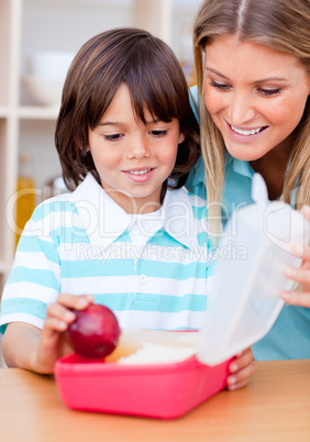 Smiling little boy and his mother preparing his snack