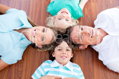 Smiling family lying in circle on the floor