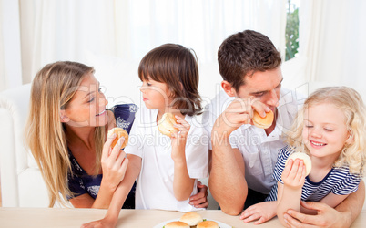 Lively family eating burgers in the living room