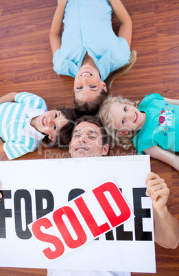 Happy family lying on floor after buying a house