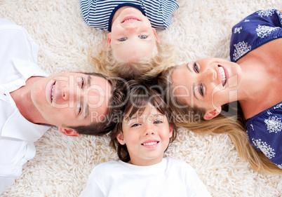 Cheerful family lying in circle on the wall-to-wall carpet
