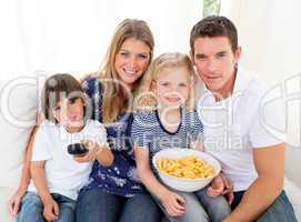 Loving family watching television sitting on sofa