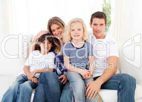 Joyful family watching television sitting on sofa