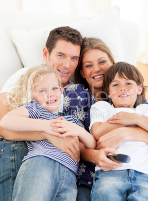 Caucasian family watching television sitting on sofa
