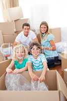 Smiling family packing boxes