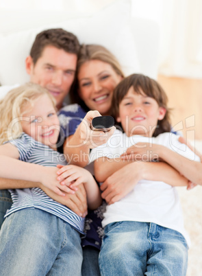 United family watching television sitting on sofa