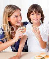 Attractive mother and her son eating burgers