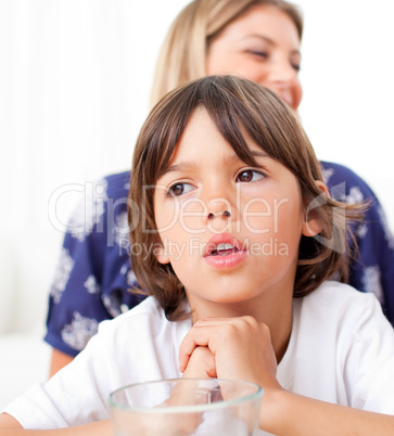 Captivated child watching television with his mother