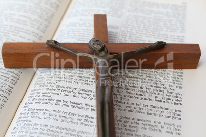 Aufgeschlagene Heilige Schrift mit einem Kruzifix