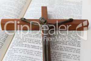 Aufgeschlagene Heilige Schrift mit einem Kruzifix