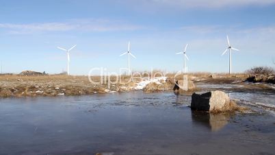 Wind farm and lake with boulder