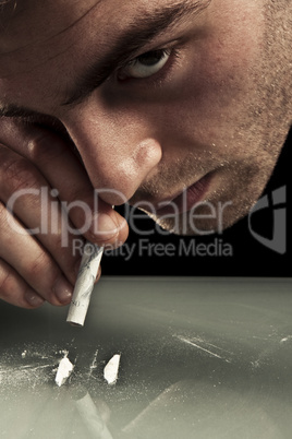 Young man sniffing cocaine.