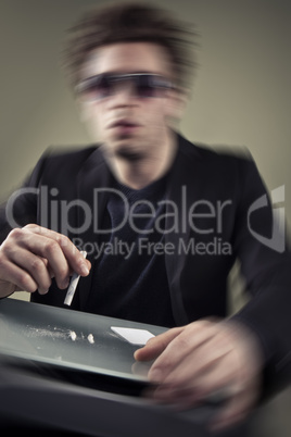 Young man sniffing cocaine.