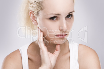 portrait of a caucasian blonde woman with toothache