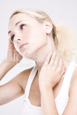 close up of a blonde woman massaging her neck