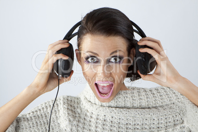 Studio portrait of a girl in headphones listening music