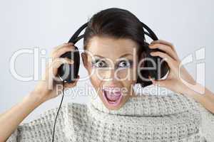 Studio portrait of a girl in headphones listening music