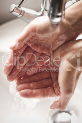 Washing hands under tap