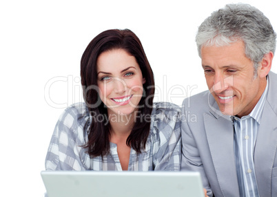 Two positive business co-workers using a laptop