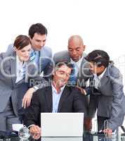 Confident international business team looking at a laptop