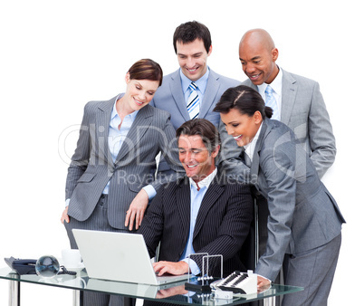 Cheerful international business team looking at a laptop