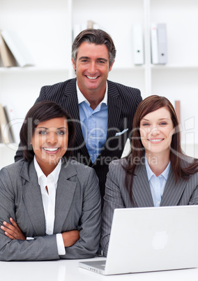 Smiling business partners using a laptop