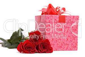 Red roses and gift box on a studio white background.