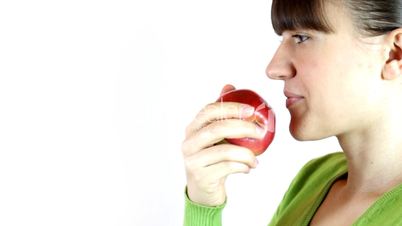 Closeup of young woman eating an apple