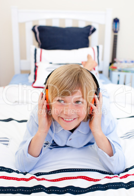 Relaxed boy listening music lying down on bed