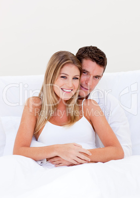 Portrait of an enamored couple sitting on bed