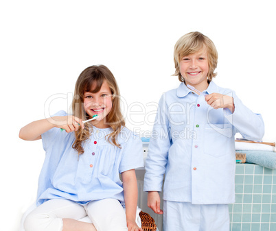Smiling brother and siter brushing their teeth