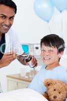 Smiling doctor examining a little boy with his father