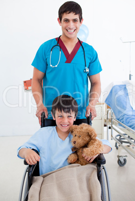 Portrait of a cute little boy sitting on wheelchair and a doctor