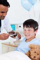 Positive doctor giving medicine to a little boy