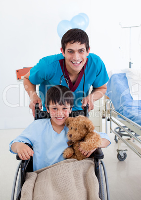 Portrait of a little boy sitting on wheelchair and a doctor