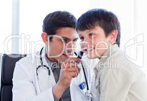 Serious doctor examining little boy's ears