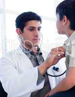 Portrait of a serious doctor examining a little boy
