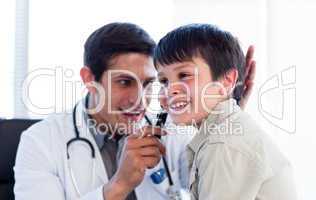 Smiling doctor examining little boy's ears