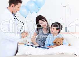 Attentive doctor talking with a little boy and his mother