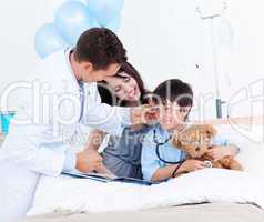 Charming doctor playing with a little boy and his mother