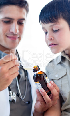 Assertive doctor giving medicine to a little boy