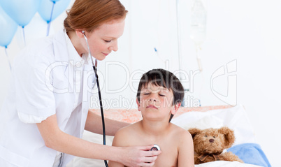 Pretty doctor examining a little boy